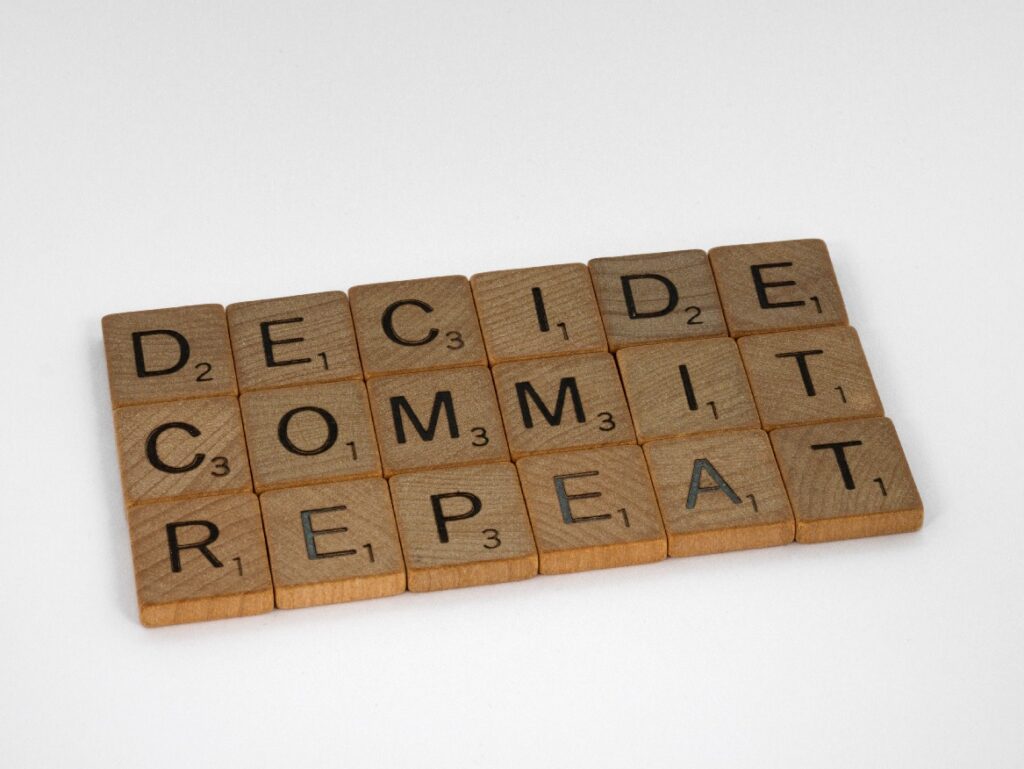 Decide Commit Repeat wooden letters